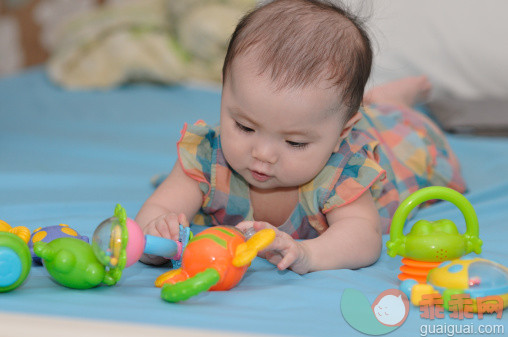 人,婴儿服装,床,玩具,室内_161797003_Baby prone playing_创意图片_Getty Images China