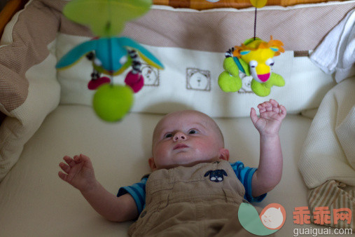 人,婴儿服装,玩具,室内,白人_129253811_Small baby in cradle with hanging toys_创意图片_Getty Images China