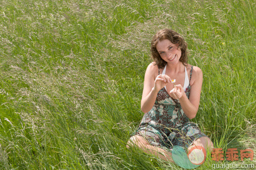 人,休闲装,连衣裙,自然,户外_145166686_Germany, North Rhine Westphalia, Duesseldorf, Young woman plucking petals of flower, smiling, portrait_创意图片_Getty Images China