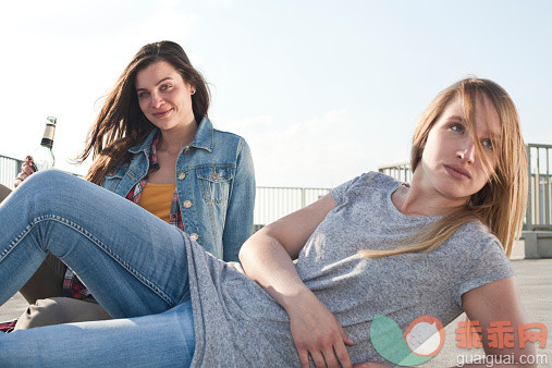 人,休闲装,城市,瓶子,四分之三身长_525469009_Germany, North Rhine-Westphalia, Cologne, two young women relaxing on parking level_创意图片_Getty Images China