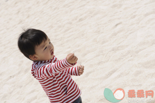 人,衣服,生活方式,度假,户外_92219458_Japanese boy with handful of sand on beach_创意图片_Getty Images China