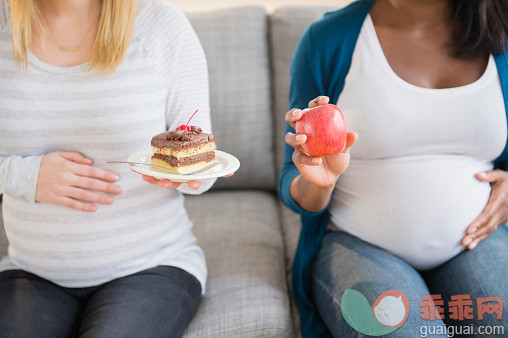 人,饮食,沙发,人生大事,生活方式_557475401_Pregnant women comparing apple and cake on sofa_创意图片_Getty Images China