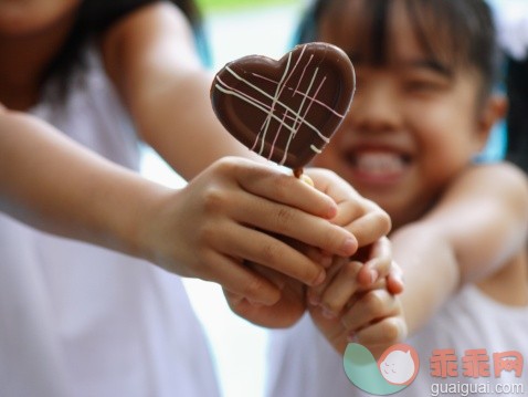 打斗,人,休闲装,食品,甜食_74228312_Close-up of two girls holding a heart shaped lollipop_创意图片_Getty Images China