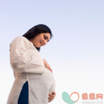 人,休闲装,四分之三身长,户外,25岁到29岁_79262080_Low angle view of a pregnant woman touching her abdomen_创意图片_Getty Images China