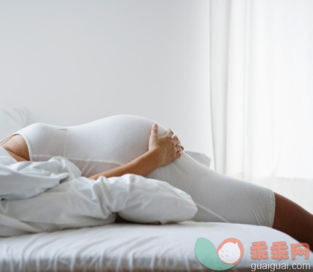 舒服,摄影,首都,人,休闲装_83749985_young pregnant woman holding belly while sleeping_创意图片_Getty Images China