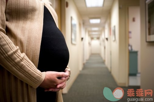 主题,健康保健,概念,人生大事,构图_200460540-005_Pregnant woman standing in hallway, holding stomach, close-up_创意图片_Getty Images China